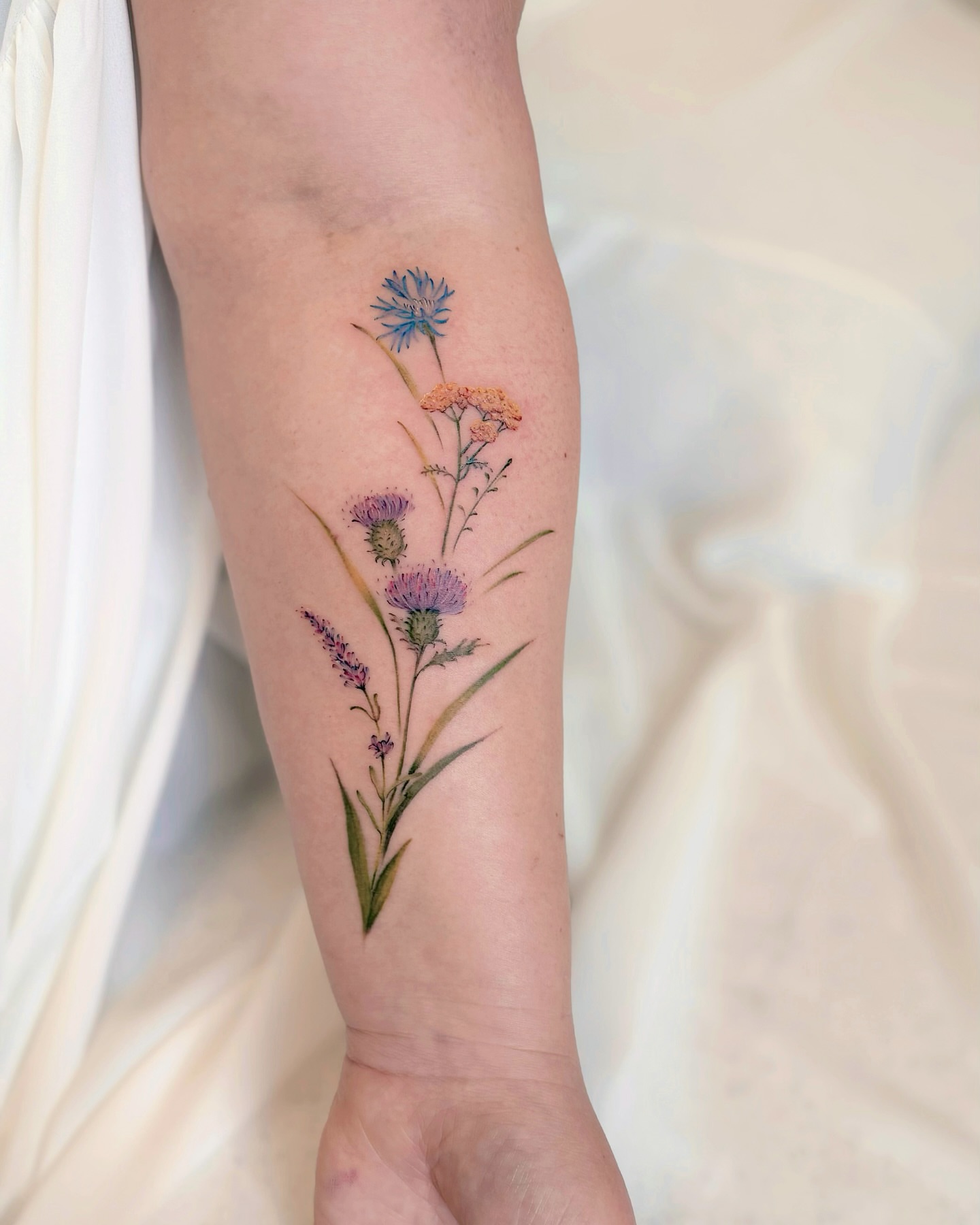 Wildflowers watercolor tattoo on the forearm by Seattle Tattoo Artist PingPing, Seattle, Washington