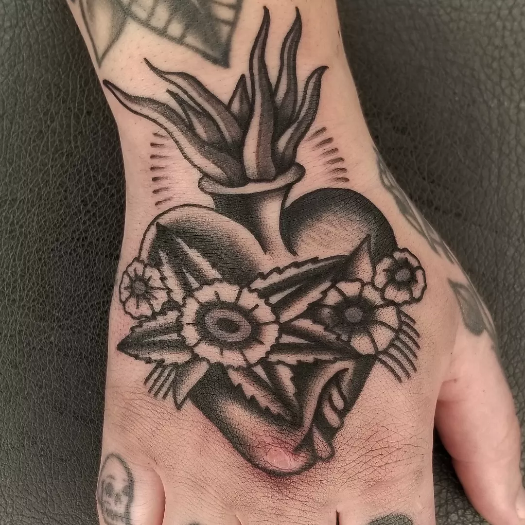 Heart with flowers American traditional tattoo on the hand by Deke Harms, Bend, Oregon