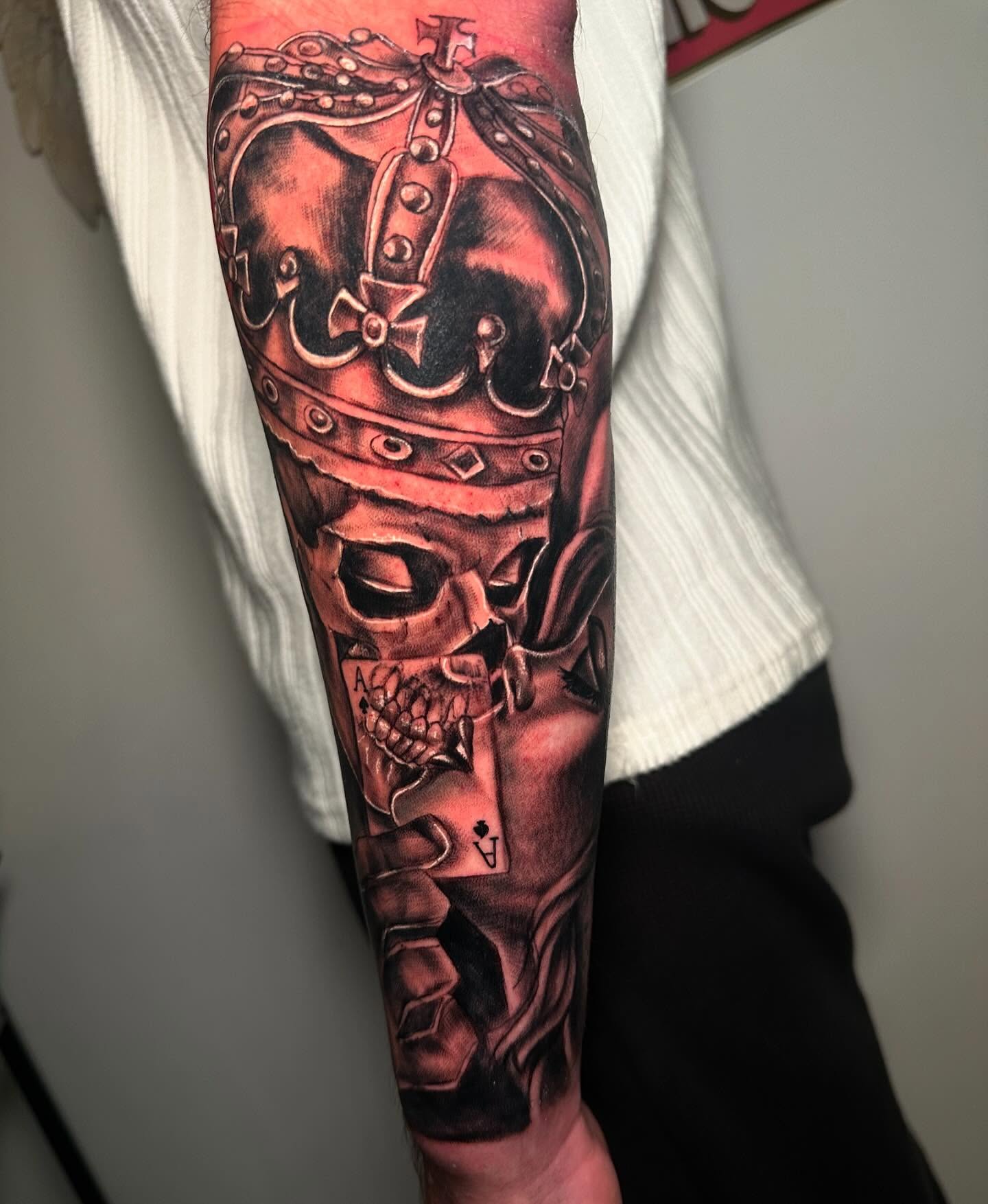 Skull wearing crown dark realism tattoo on the forearm by Anghel Patricia