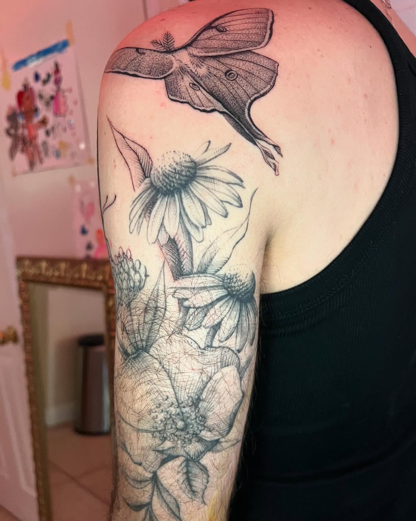 Moth and flowers realism tattoo on the upper arm by Natasha