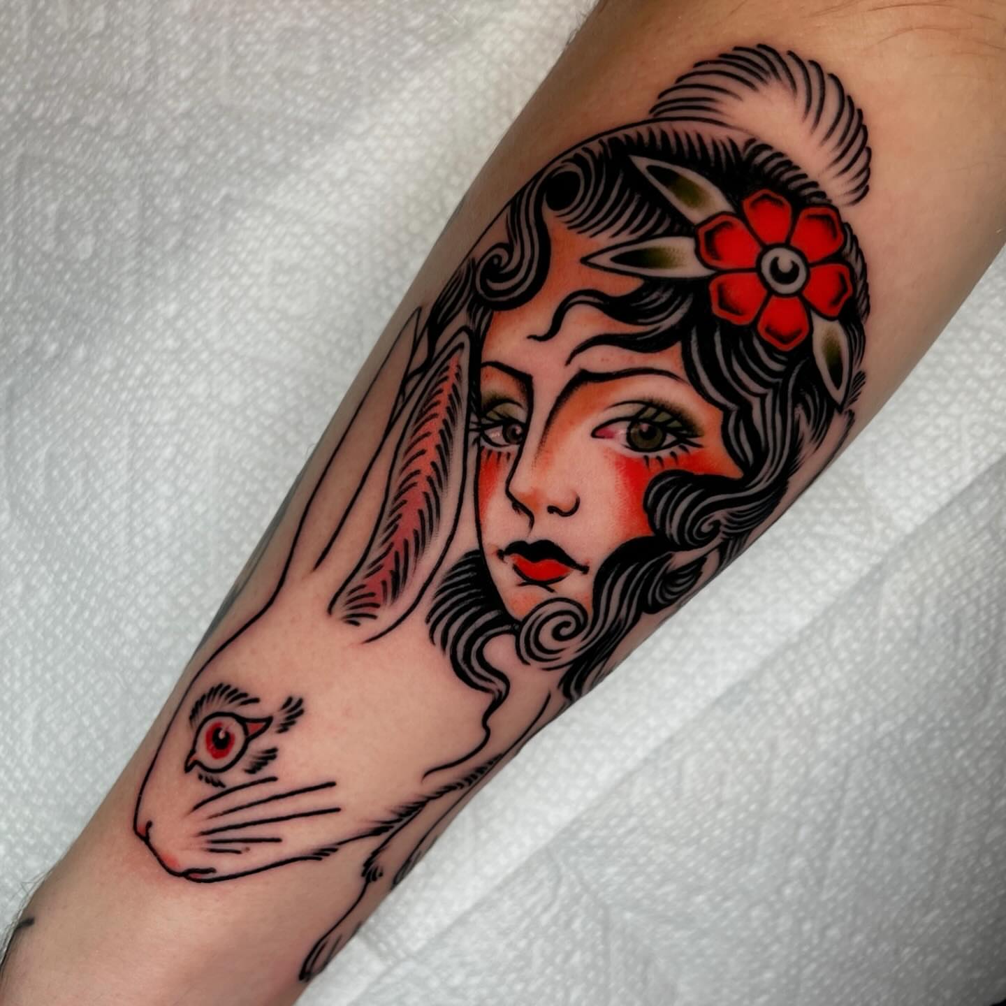 Woman with rabbit American traditional tattoo on the forearm by Hailey Johnson