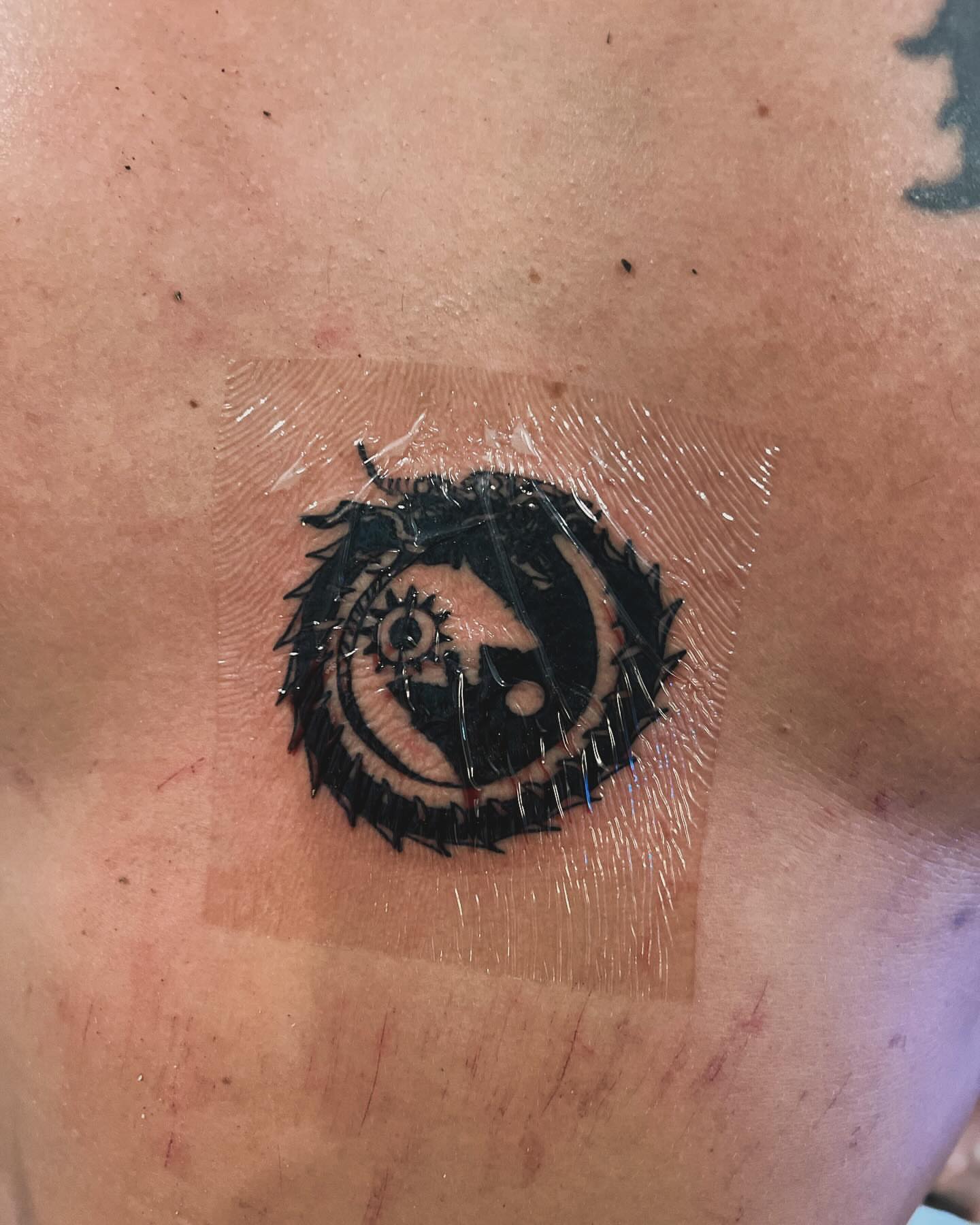 Mask with sun black and grey tattoo on the chest by Anna DeLuna
