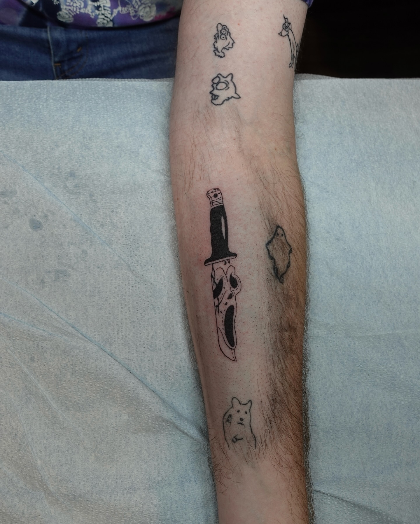Knife and ghost black and grey tattoo on the forearm by Tat by Brendan