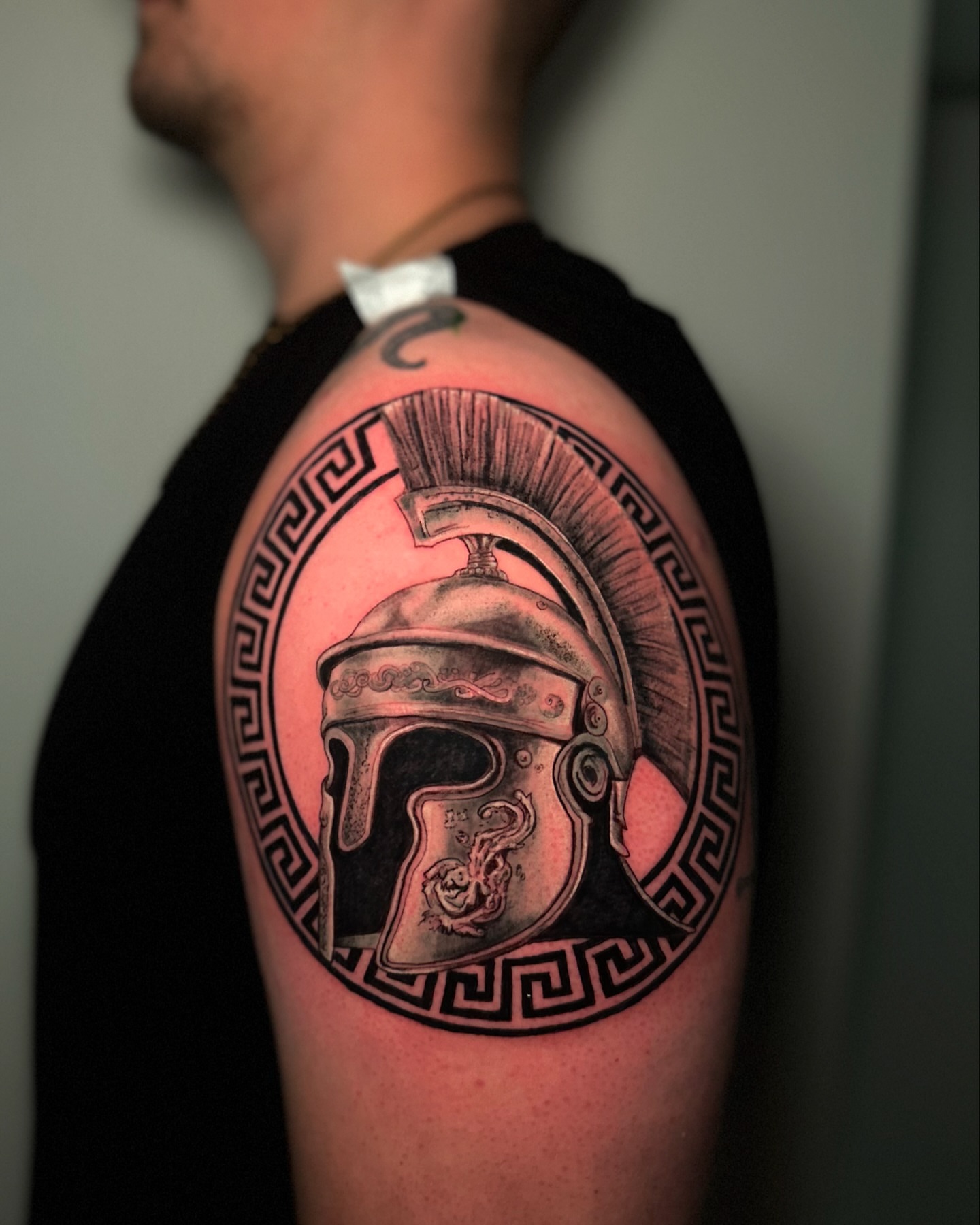 Spartan helmet black and grey tattoo on the shoulder by Héctor Agudelo