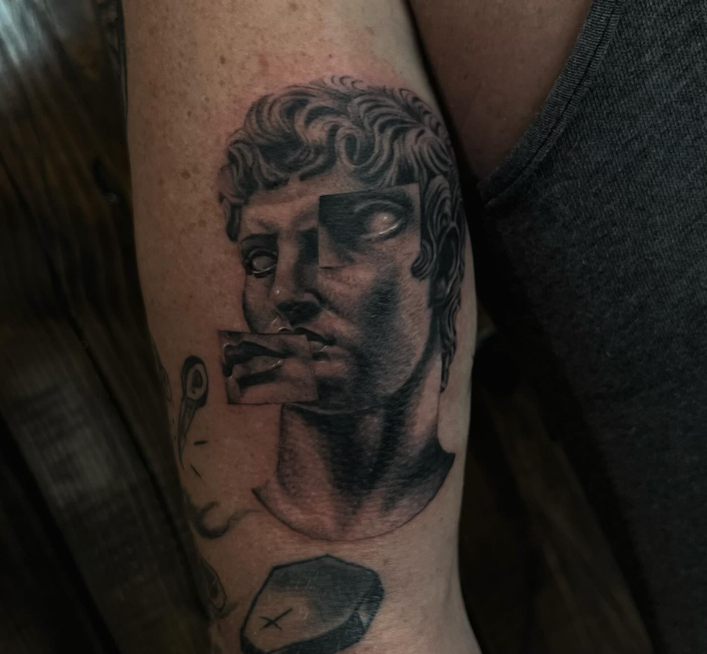 Statue head realism tattoo on the forearm by Lee Ranco