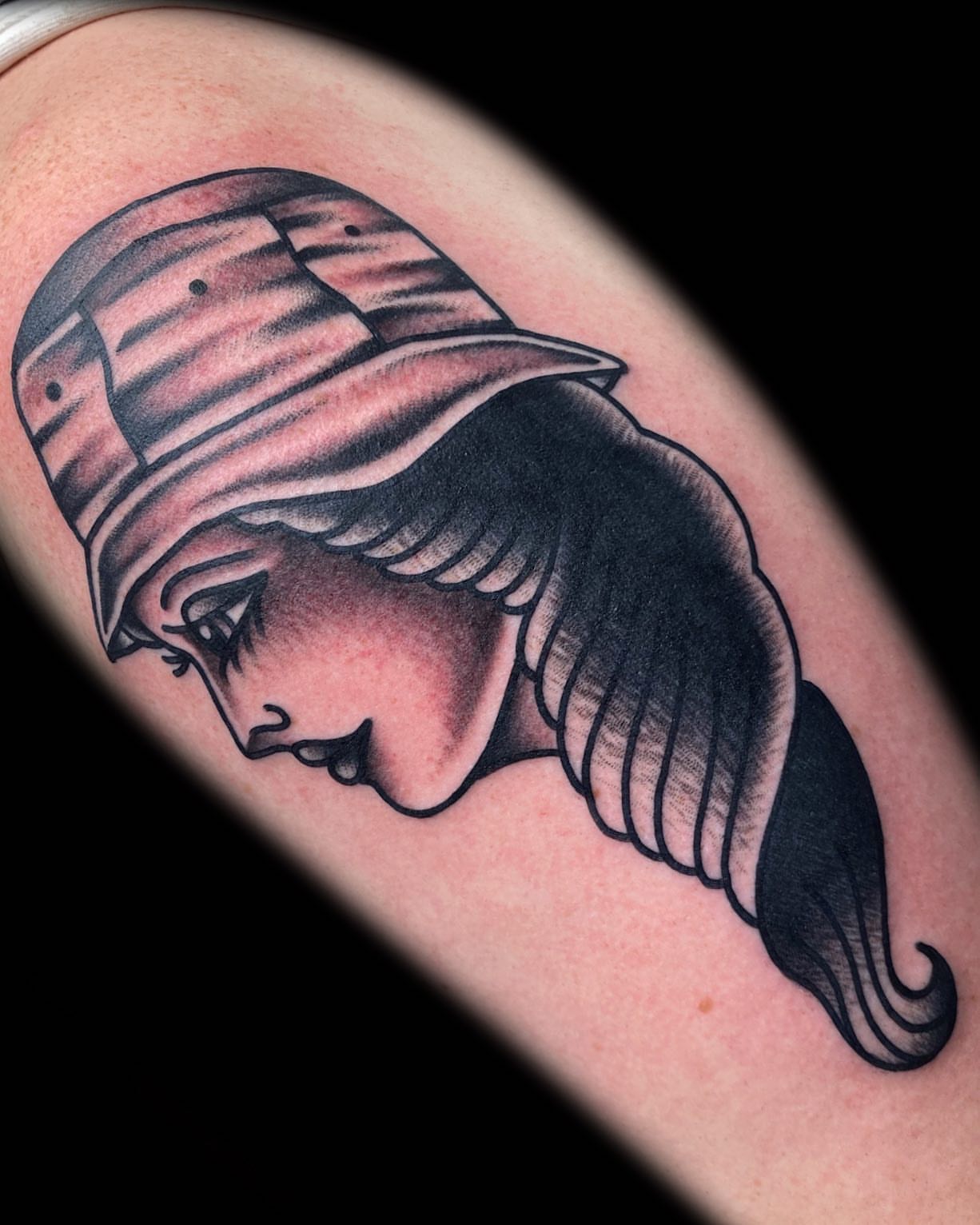 Woman with hat black and grey tattoo on the forearm by The Calamari Kid