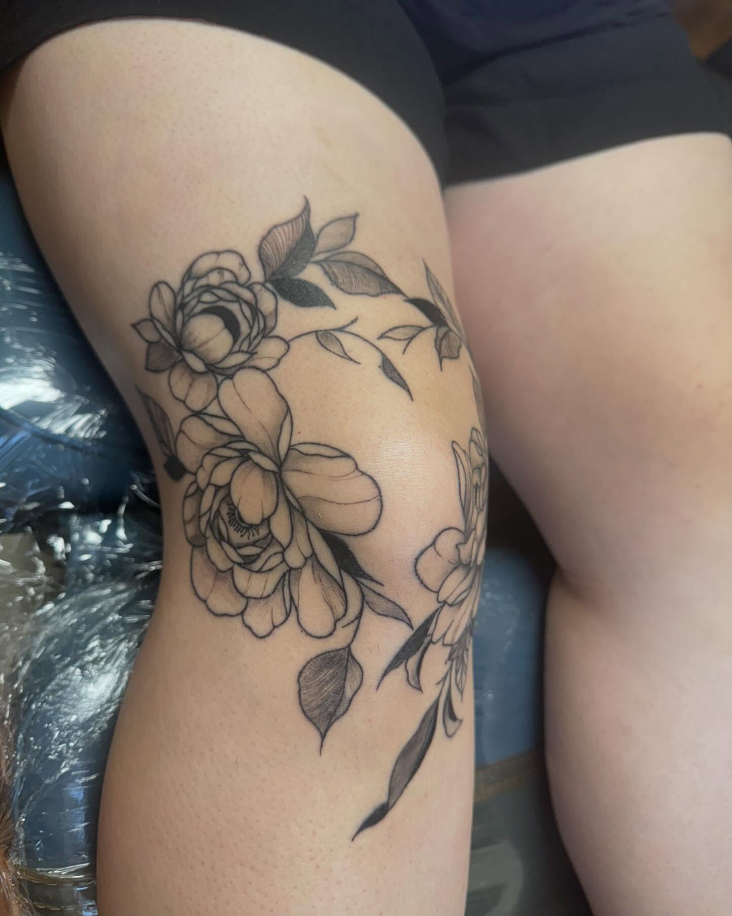 Floral arrangement black and grey tattoo on the thigh by Mickey