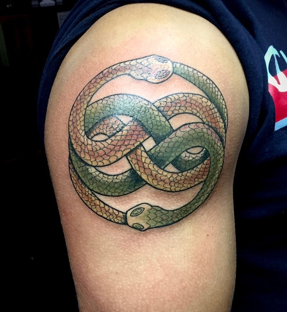 Interwoven snake geometric tattoo on the shoulder by Kenny Buck