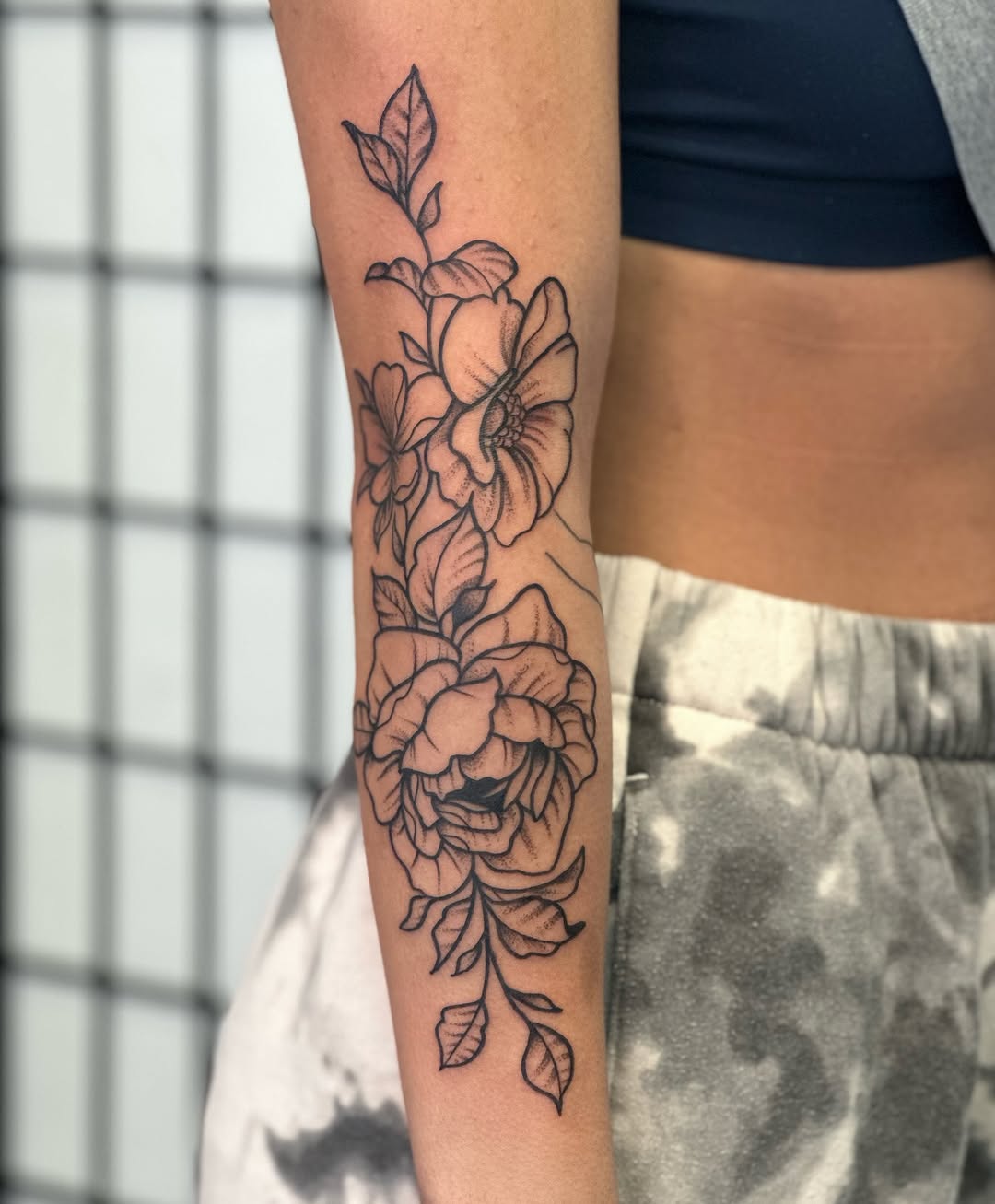 Floral arrangement fine line tattoo on the forearm by CJ