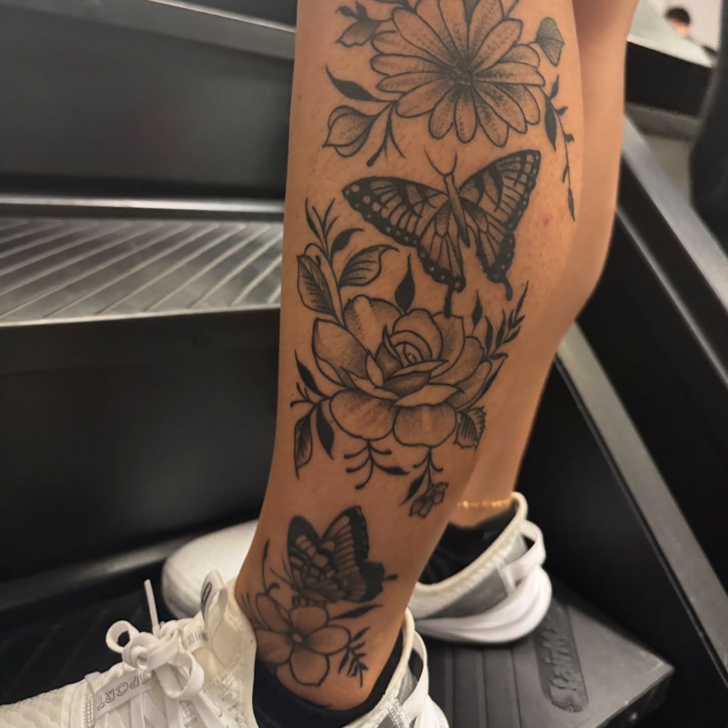 Butterfly and flowers black and grey tattoo on the forearm by Steve