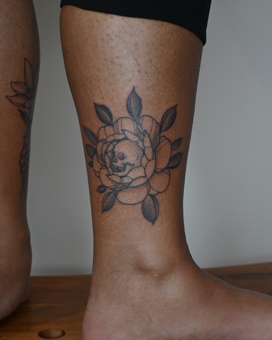 Flower with skull American traditional tattoo on the calf by Simba Nguyen