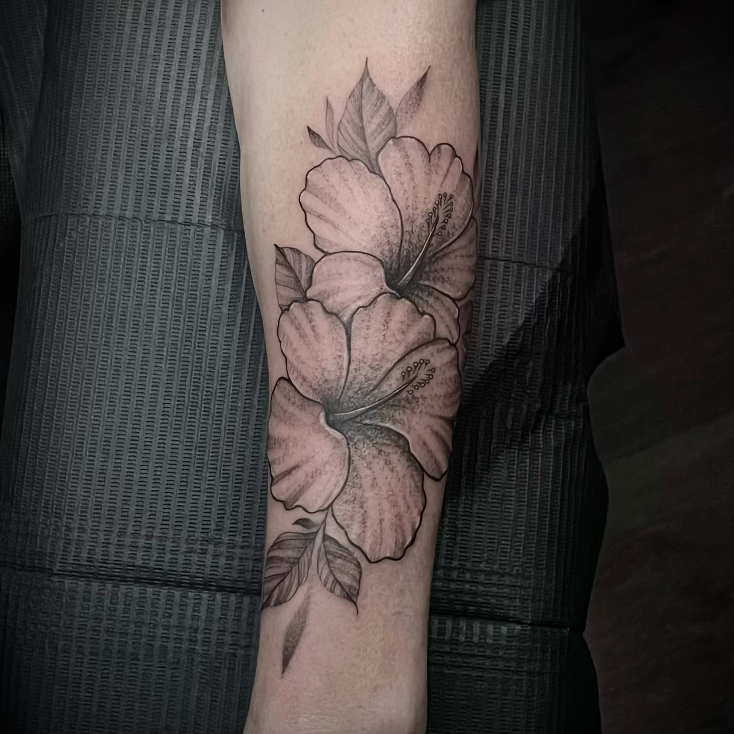 Hibiscus flowers black and grey tattoo on the forearm by Eric Axle
