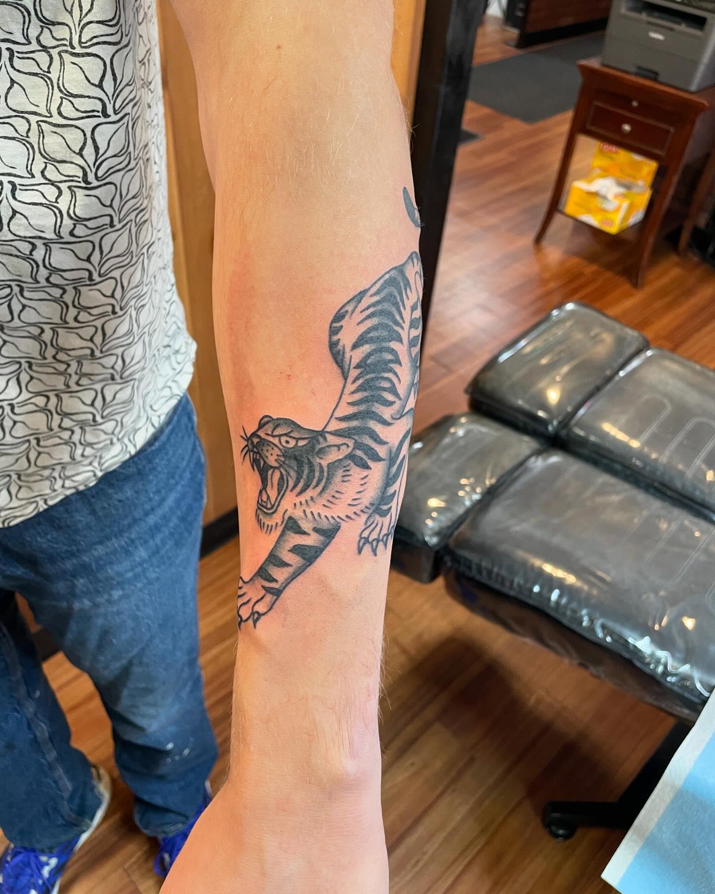 Roaring tiger black and grey tattoo on the forearm by Anna sabrowsky