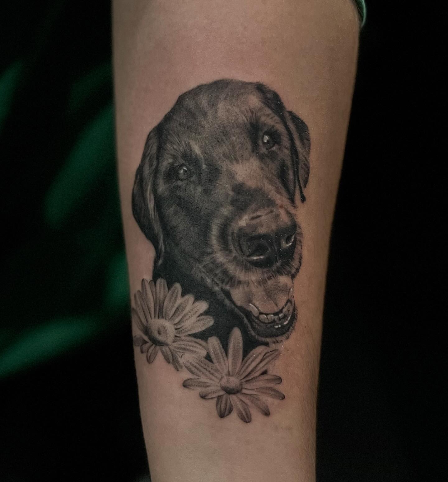 Dog with flowers realism tattoo on the forearm by Lee Ranco