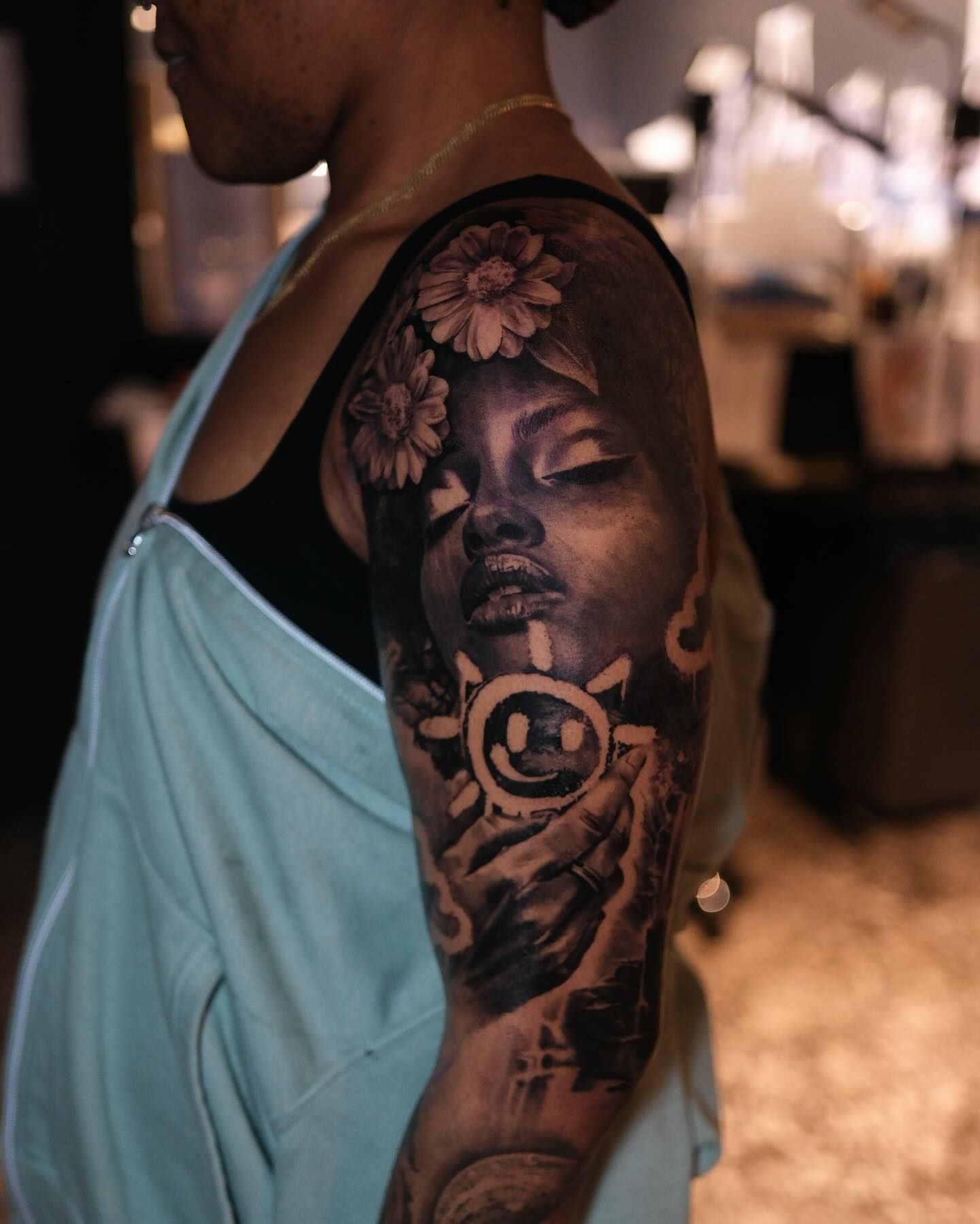 Woman's face with flowers realism tattoo on the upper arm by Joel: Boston Tattoo Artist, Boston, Massachusetts