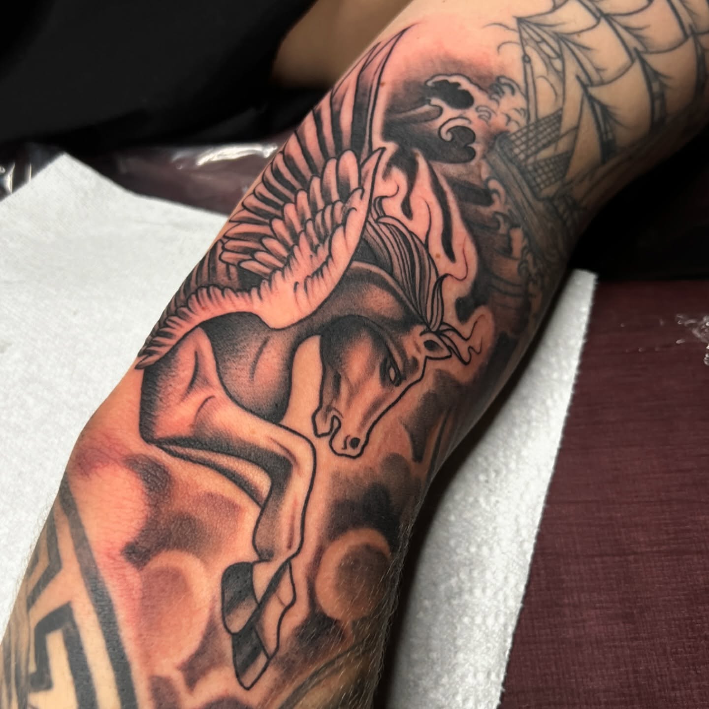 Pegasus black and grey tattoo on the forearm by Nick Ochoa