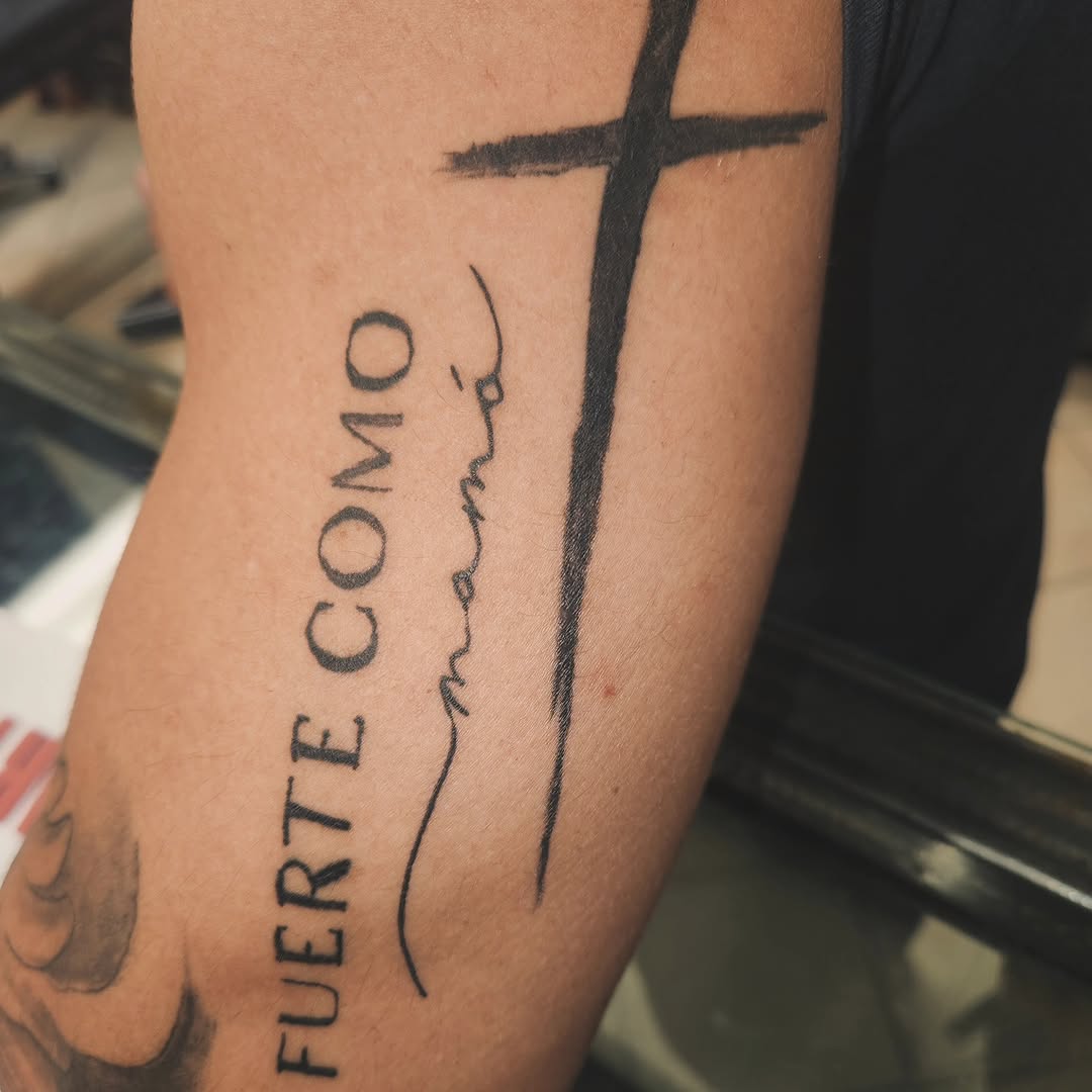 Cross and lettering lettering tattoo on the forearm by Lopez Dautruche