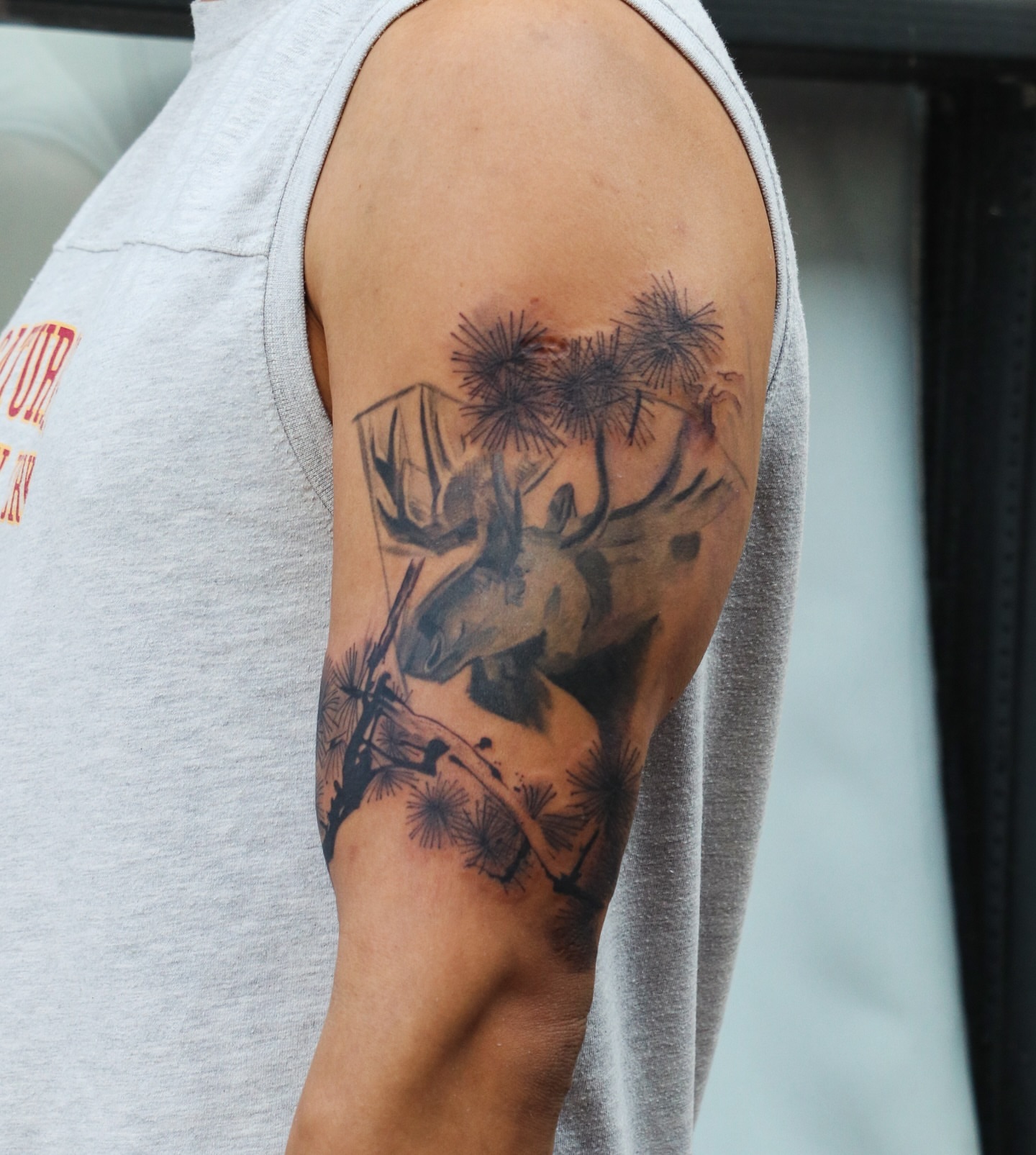 Moose and dandelions realism tattoo on the upper arm by Jhenn