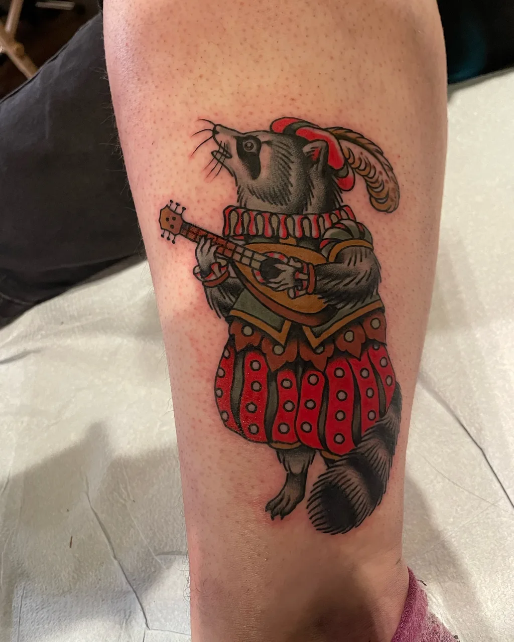 Raccoon playing guitar American traditional tattoo on the forearm by Lauren Vandevier