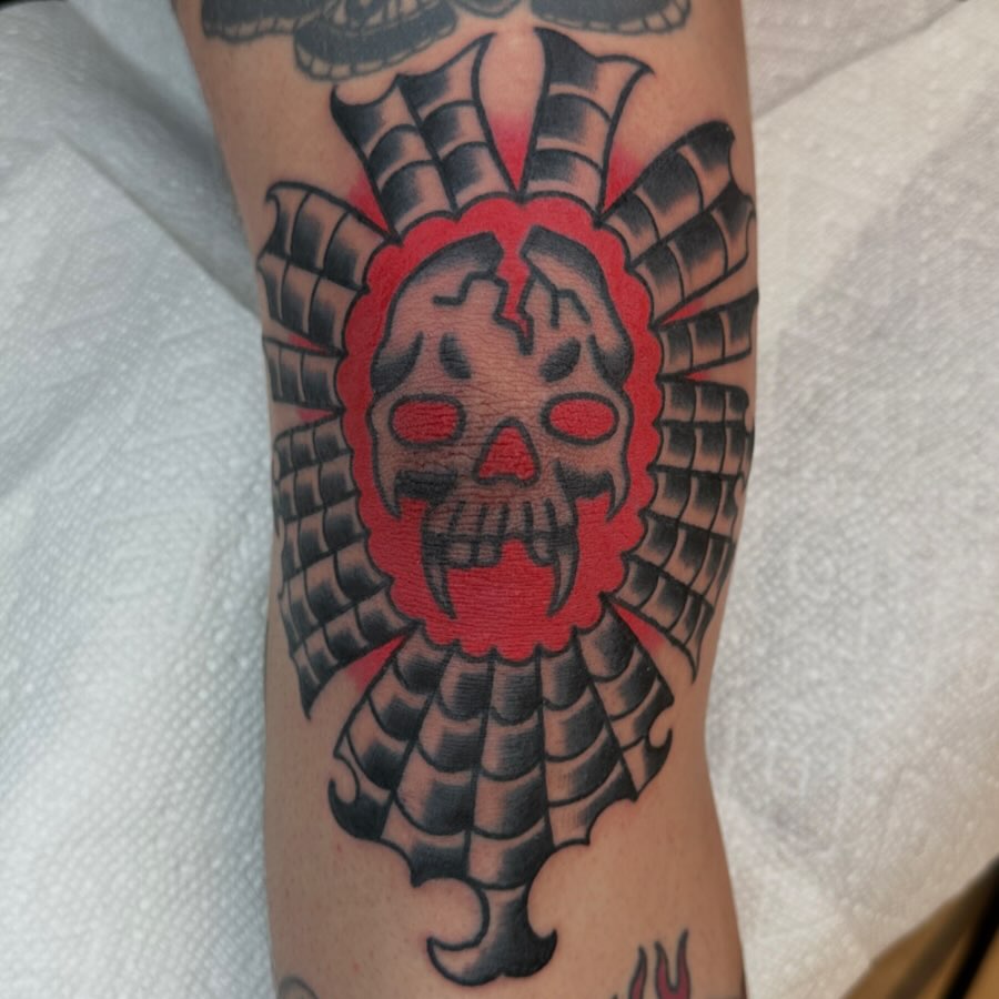Skull with feathers American traditional tattoo on the forearm by Keon Ostby, Tempe, Arizona
