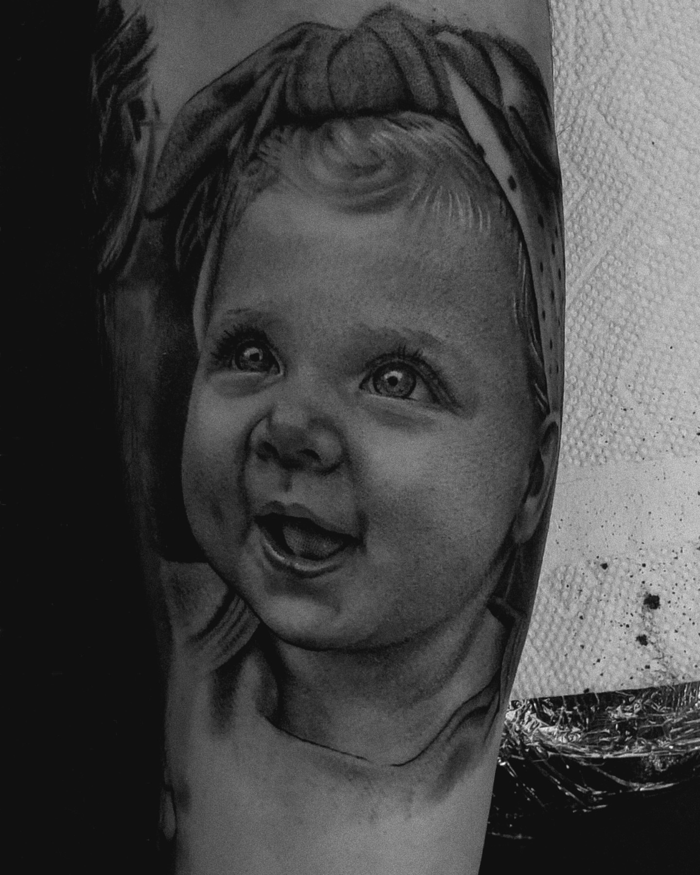 Child's face realism tattoo on the forearm by Dani Ryan