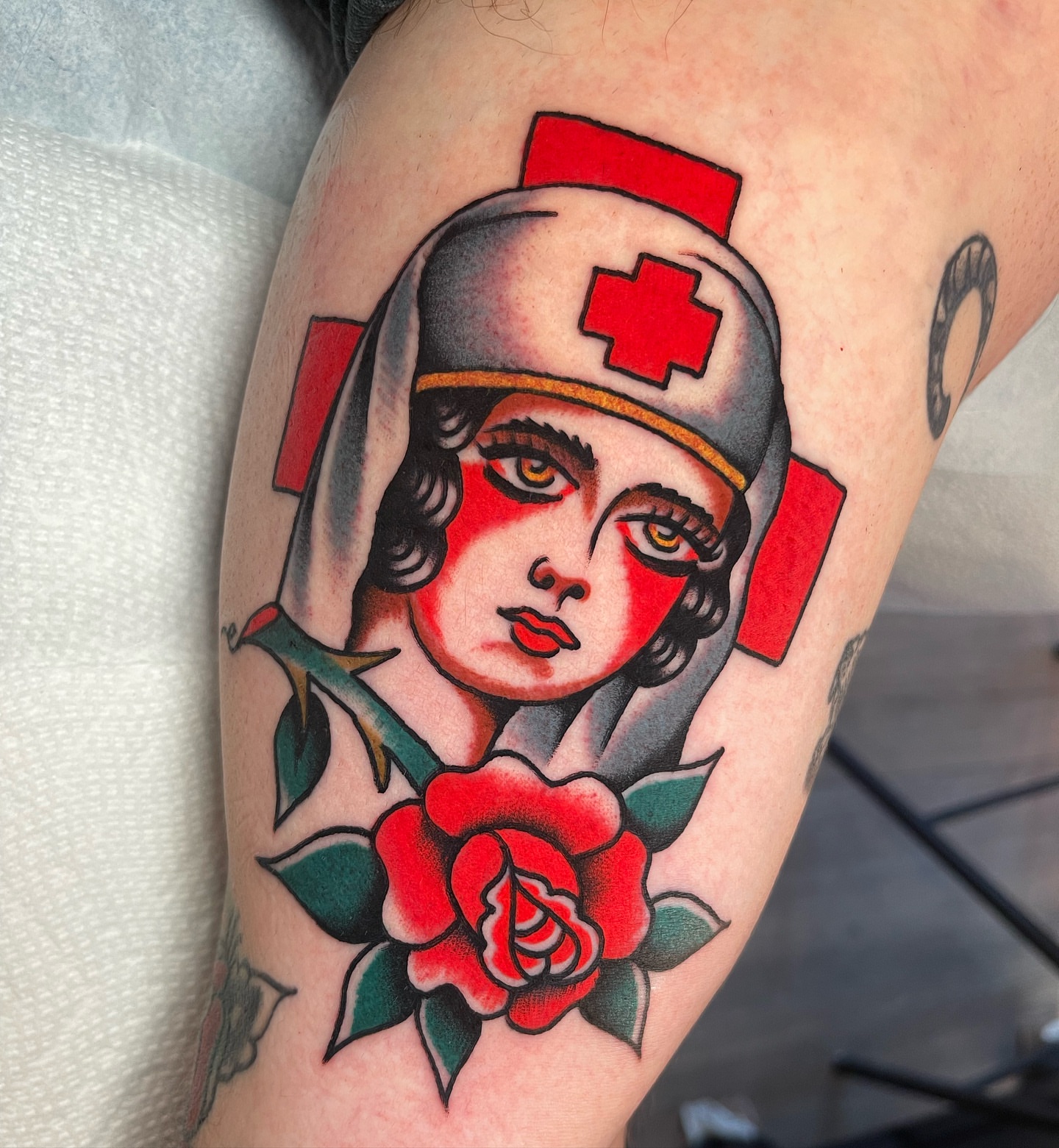 Nurse with rose American traditional tattoo on the thigh by Jeff Miller philly traditional tattoo