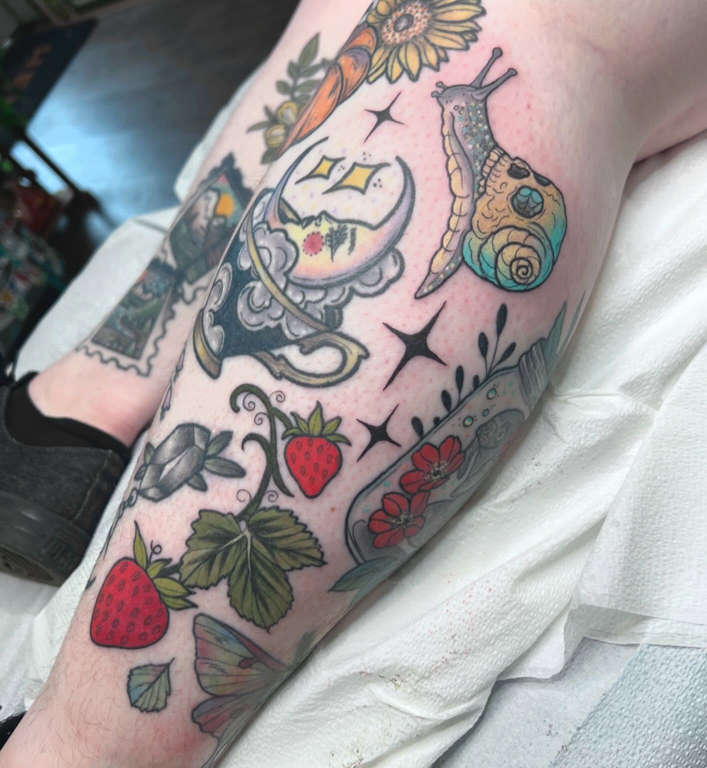 Strawberries and snail new school tattoo on the forearm by Caitlin Stairs