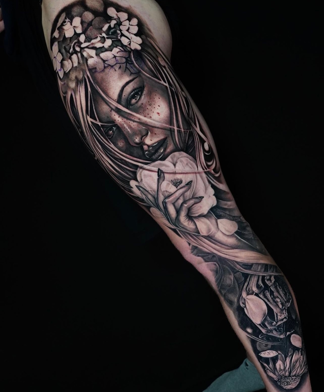 Woman with flowers realism tattoo on the forearm by JoannaTattoos