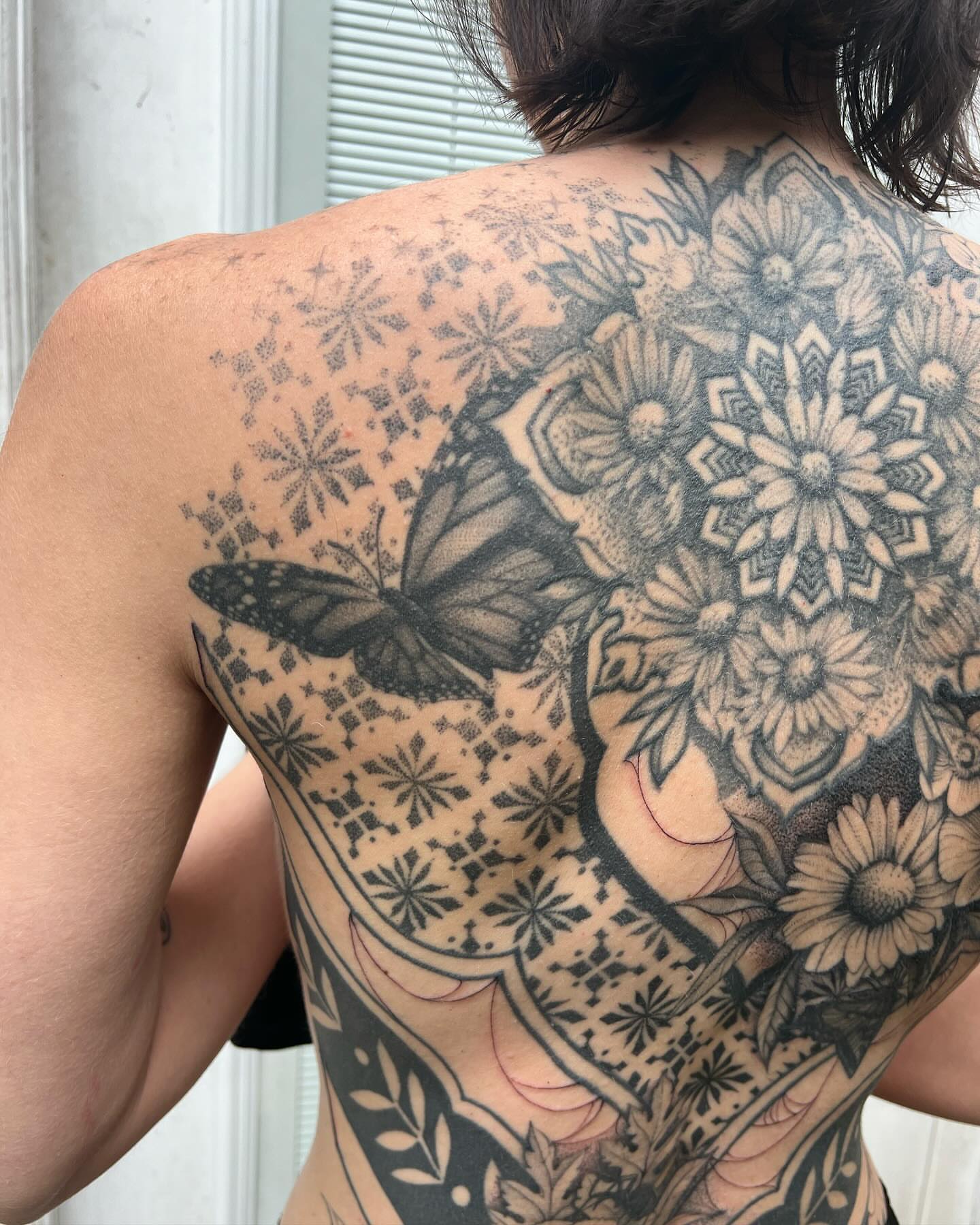 Butterfly and floral geometric tattoo on the back by Natasha