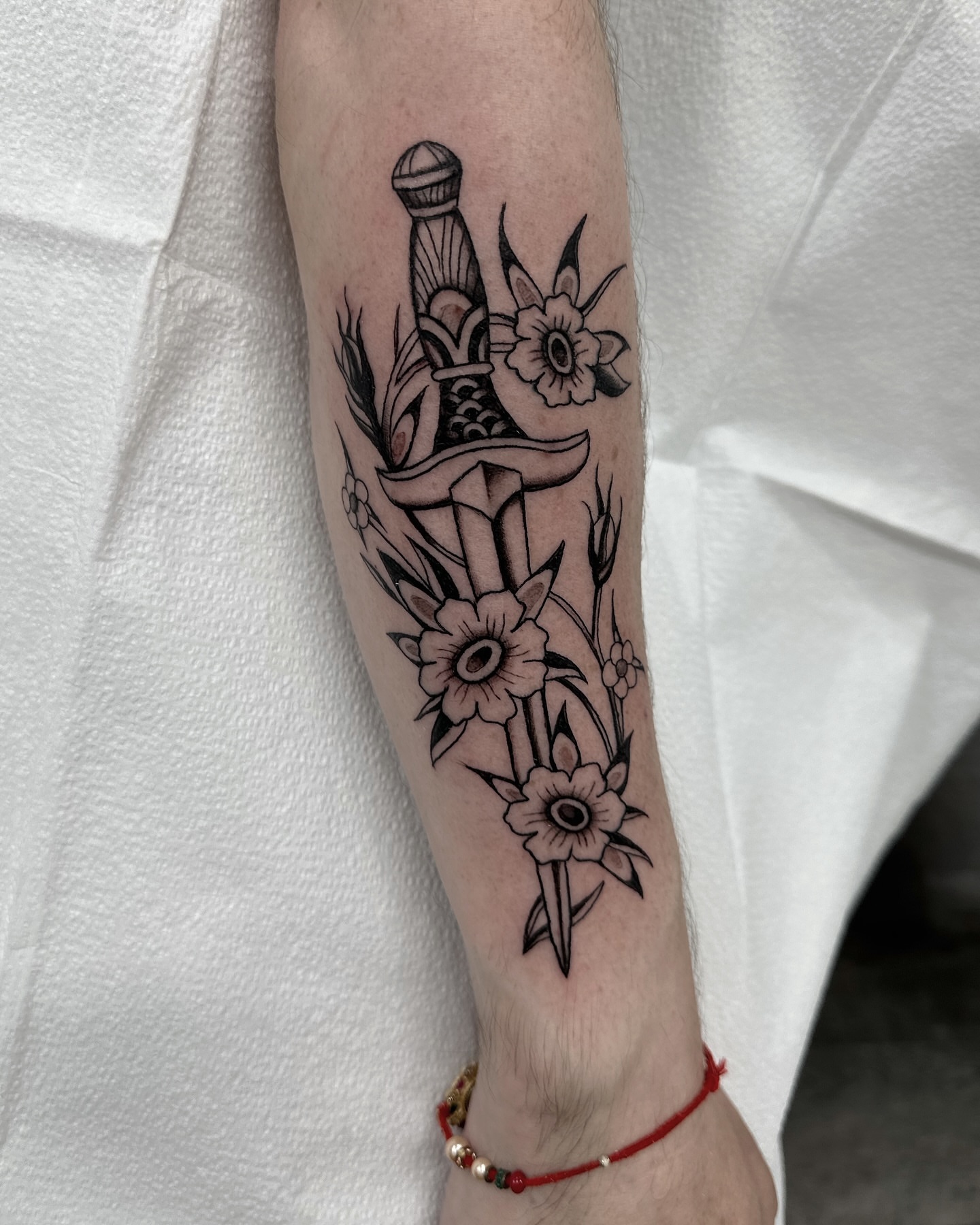 Sword and flowers black and grey tattoo on the forearm by Nicholas Lee, San Francisco, California