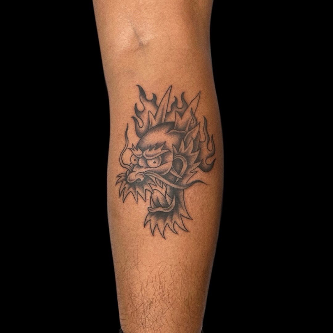 Flaming dragon head black and grey tattoo on the forearm by Jason