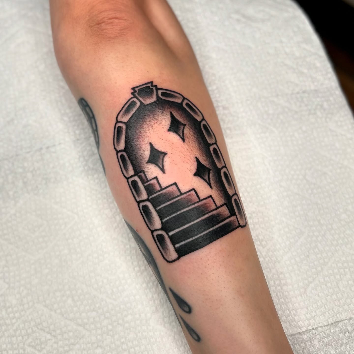 Staircase with stars black and grey tattoo on the forearm by Bright-bold-classic Tattoos, North Hills