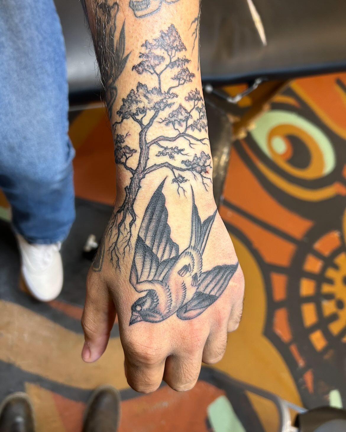 Bird and tree black and grey tattoo on the hand by Sam Perry, Denver, Colorado