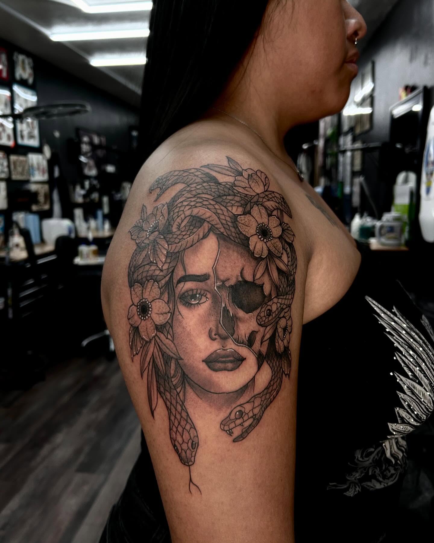 Woman's face with snakes and flowers realism tattoo on the shoulder by Jelly