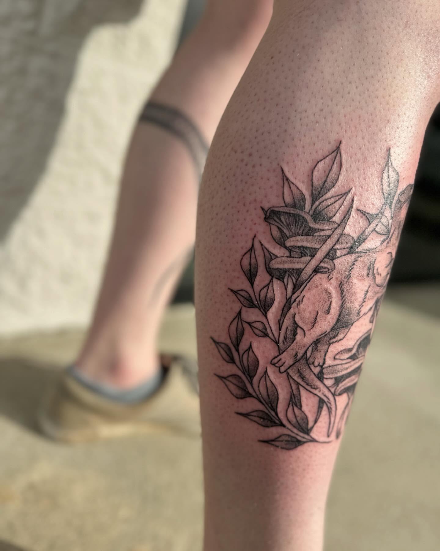 Monkey and leaves black and grey tattoo on the thigh by Marissa Losier