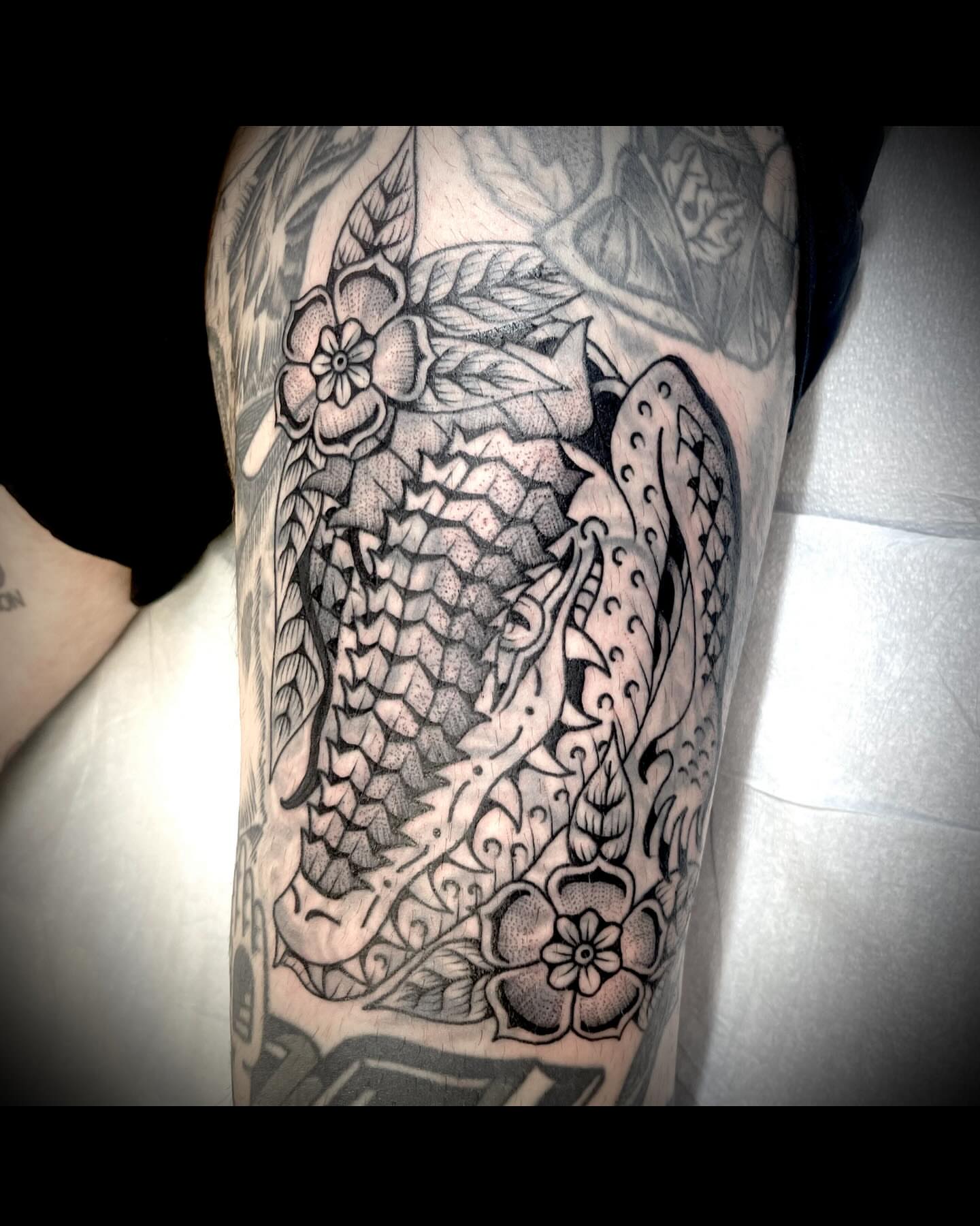 Dragon and flowers American traditional tattoo on the thigh by Jason Ryan