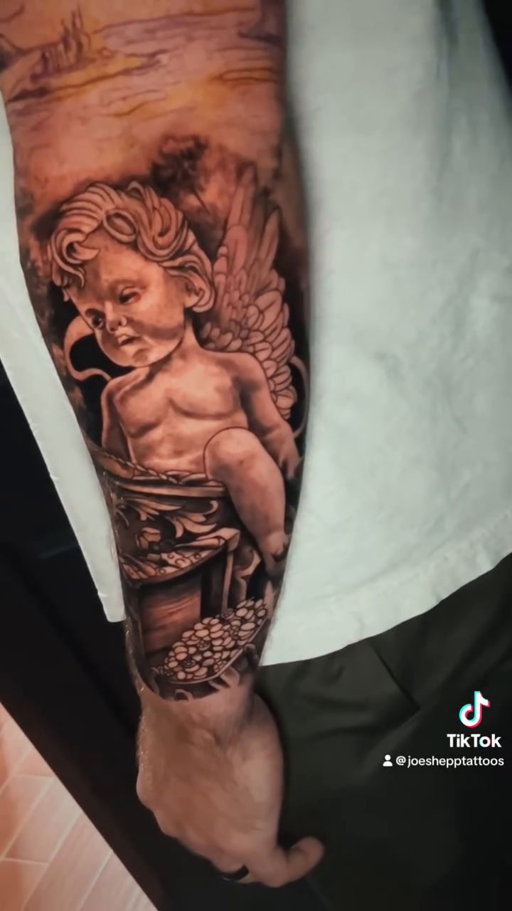 Cherub with a drum realism tattoo by Joe Shepp