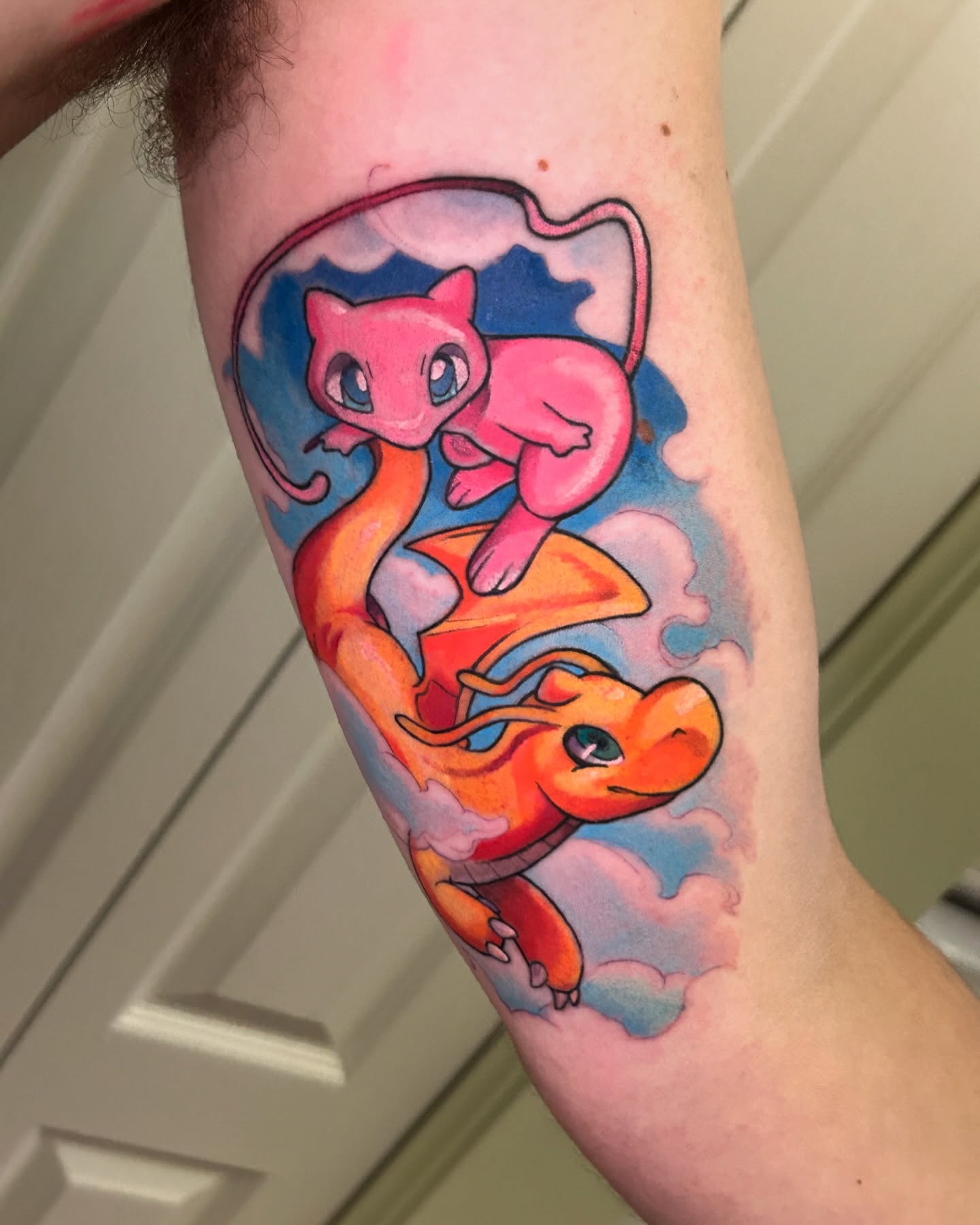 Charizard and mew new school tattoo on the forearm by Mando Castro