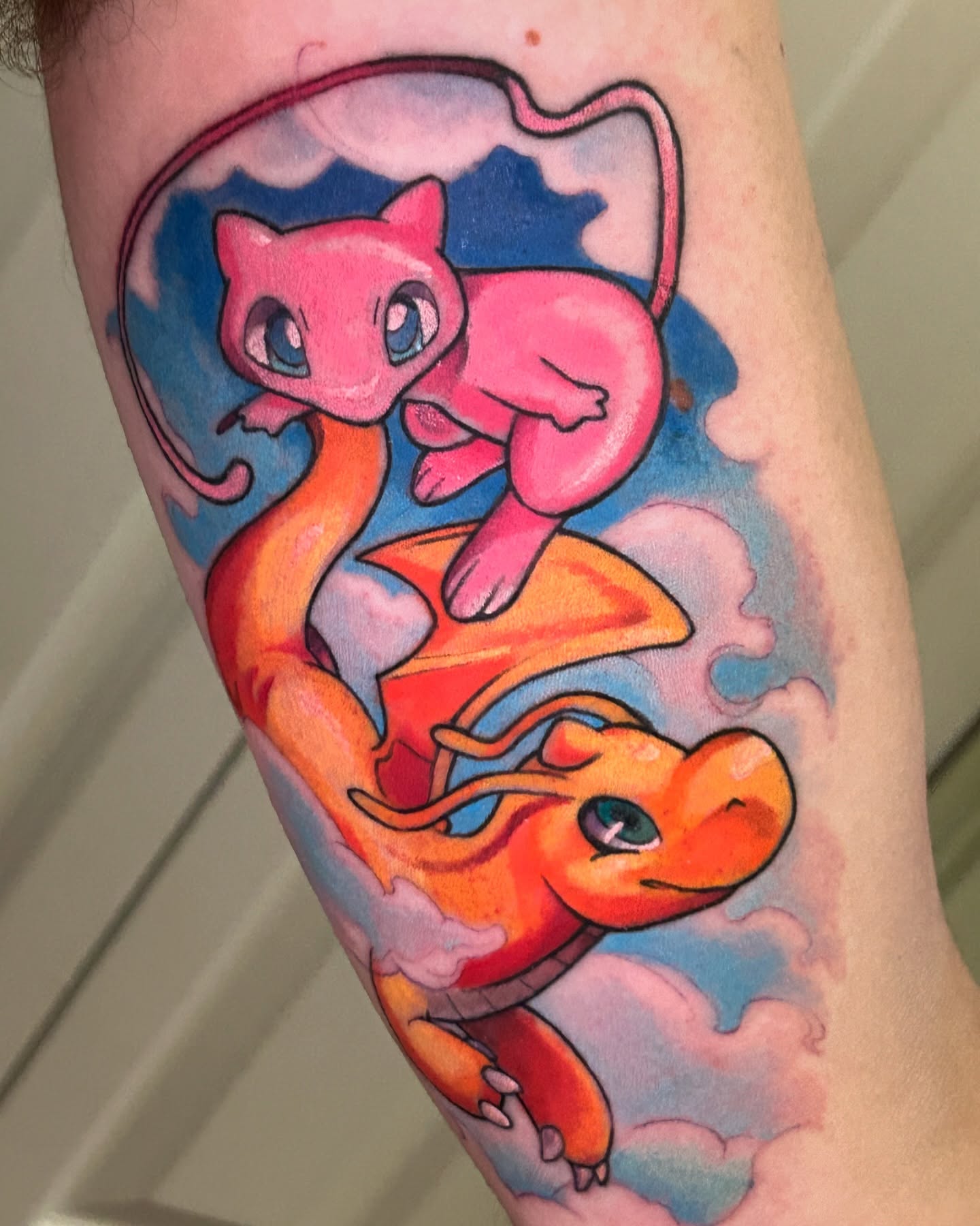 Charizard and mew dotwork tattoo on the forearm by Mando Castro