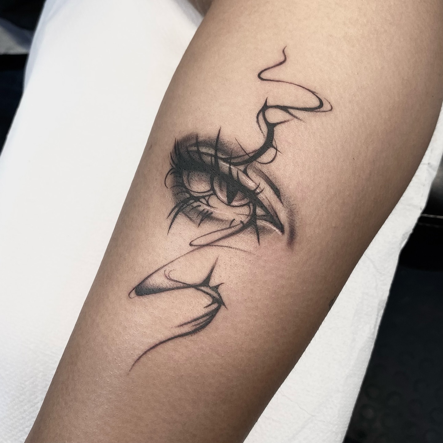 Eyelashes black and grey tattoo on the forearm by IVY