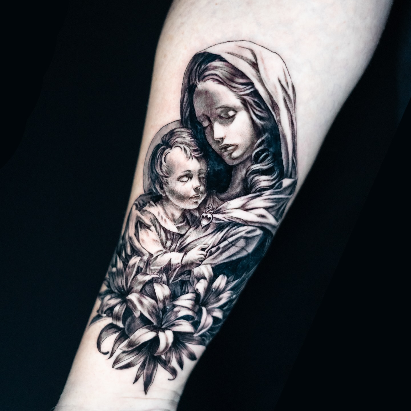 Religious figure with child realism tattoo on the forearm by James Jurado