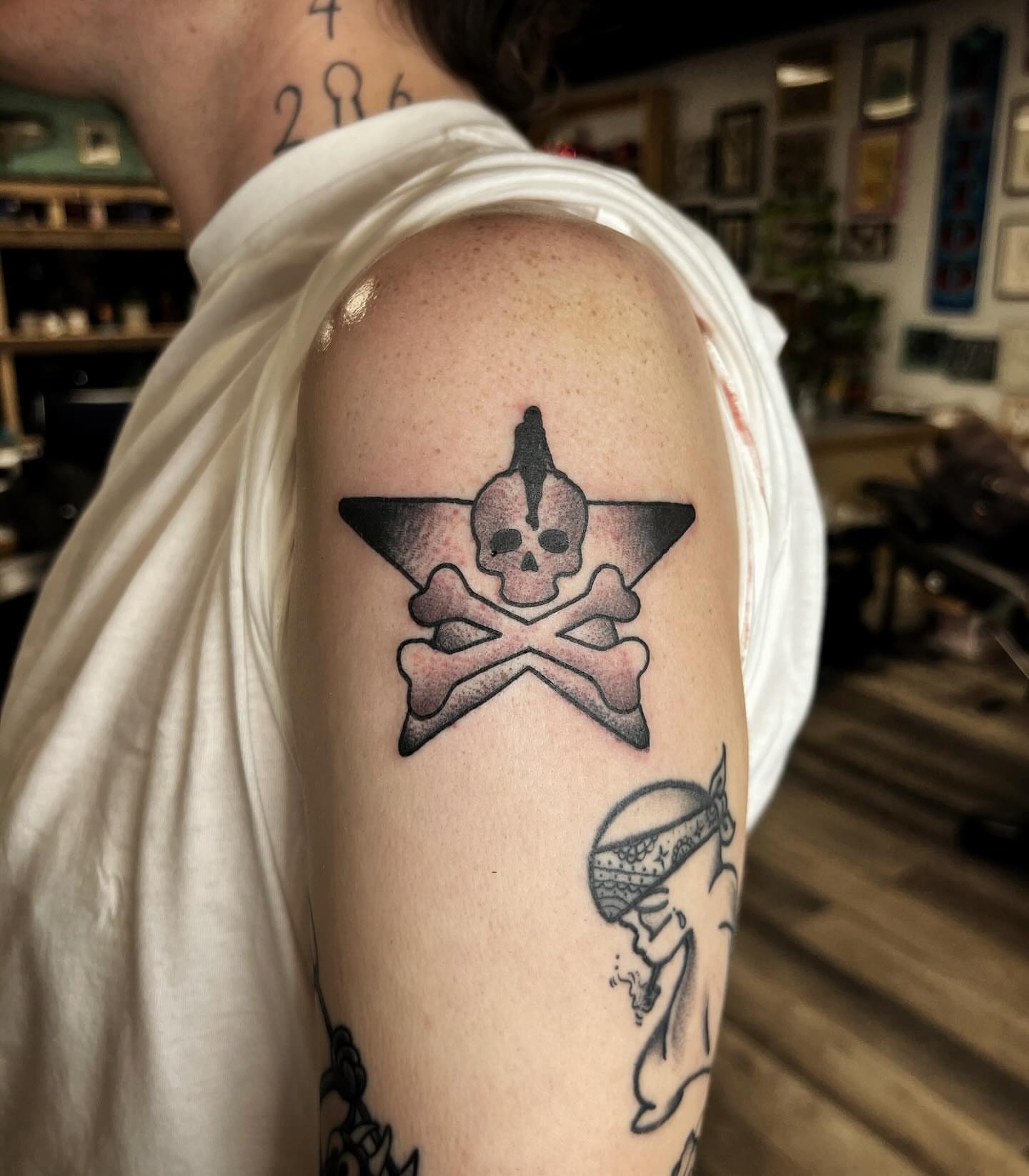Skull and crossbones black and grey tattoo on the shoulder by @sloanxkettering