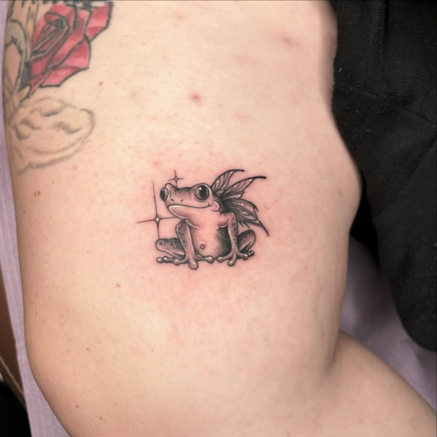 Frog with wings black and grey tattoo on the thigh by Amber N