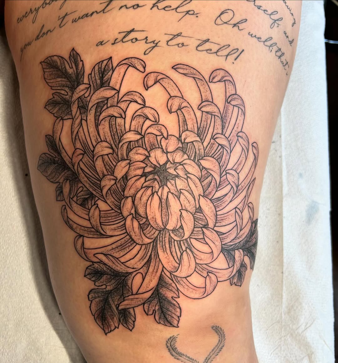 Chrysanthemum and lettering neo-traditional tattoo on the thigh by Jaime Gaiti