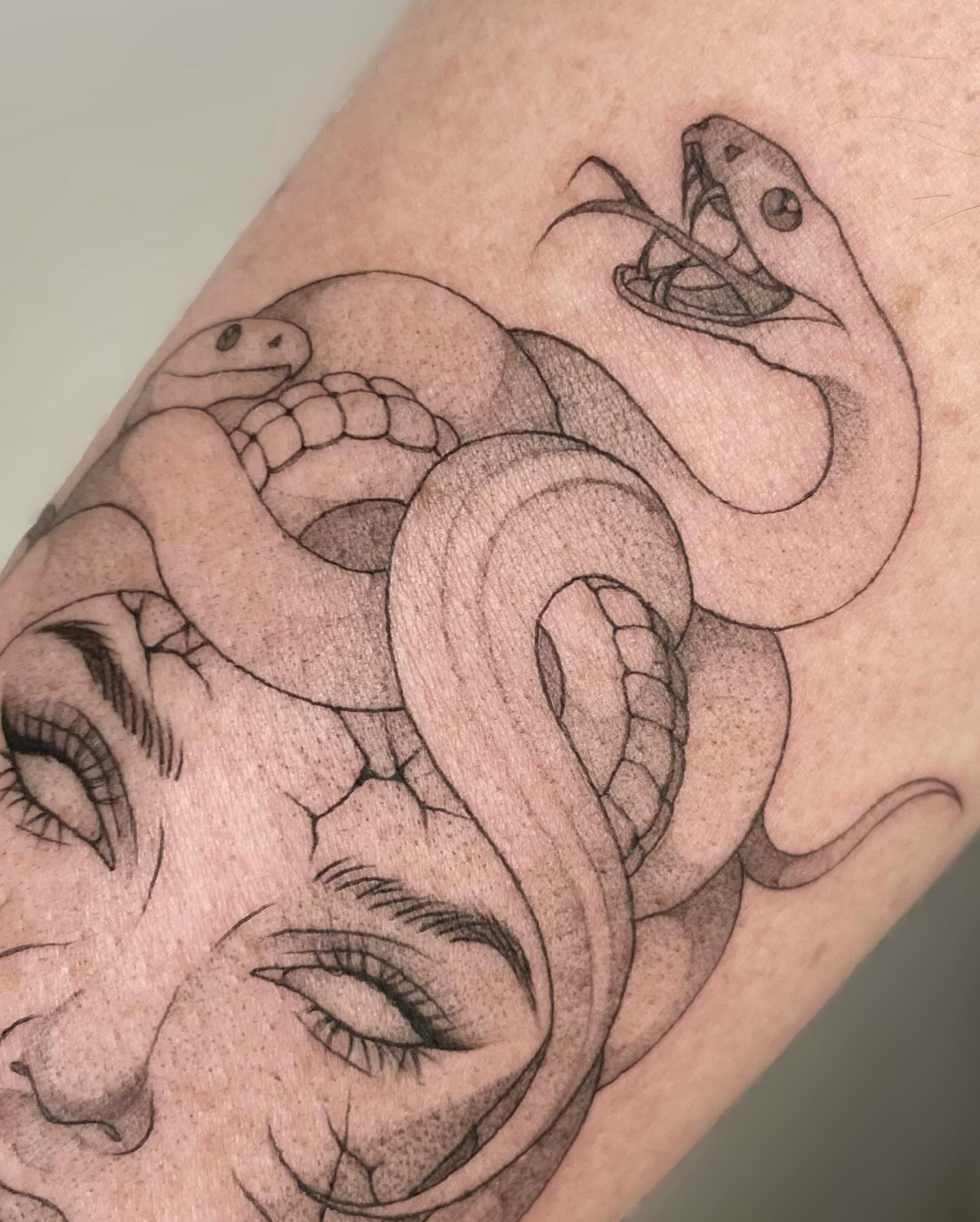 Snake and face realism tattoo on the forearm by seattle tattoo artist