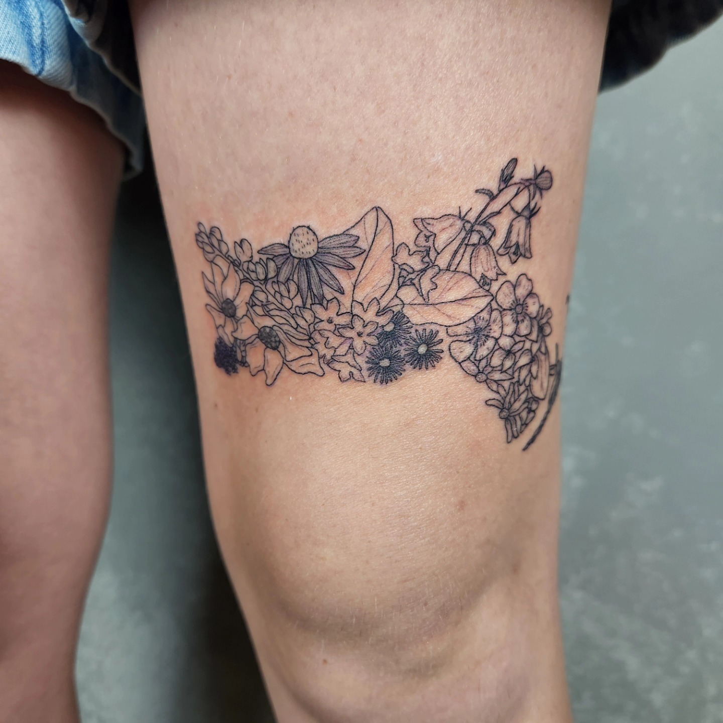 Floral arrangement black and grey tattoo on the forearm by Amy Heath