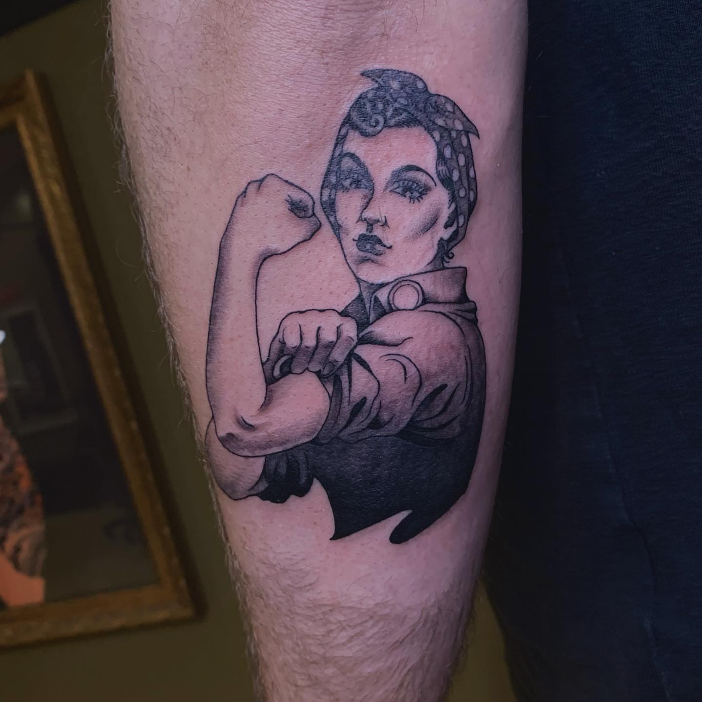 Strong woman flexing black and grey tattoo on the forearm by Tad Fulkerson, San Francisco, California