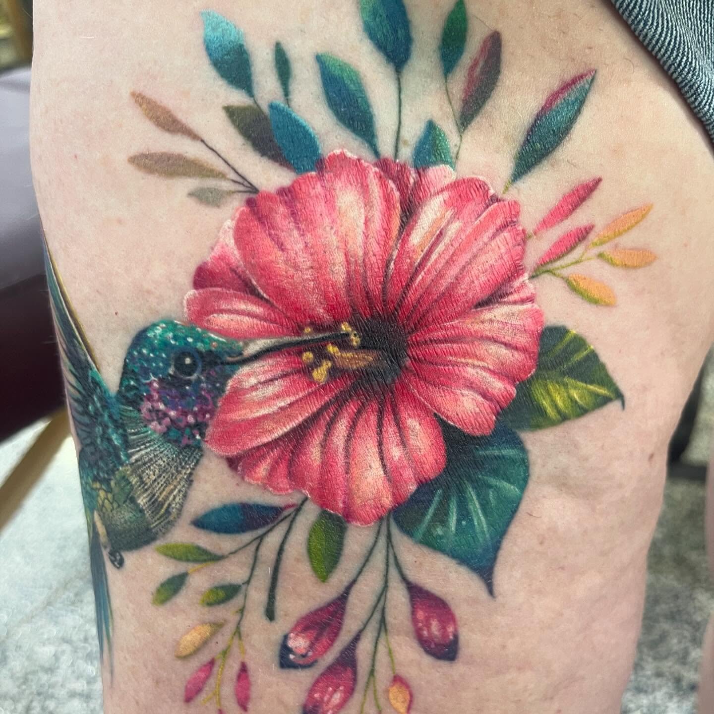 Hummingbird and hibiscus realism tattoo on the thigh by Troy Butner
