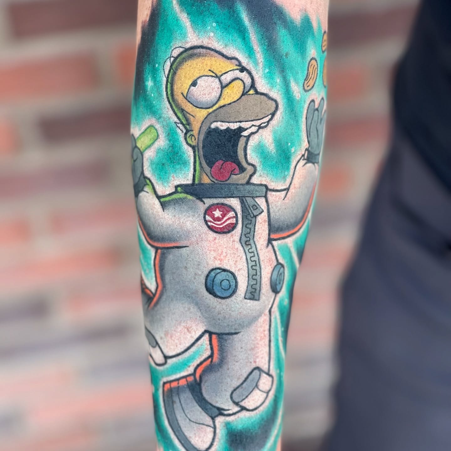 Homer Simpson astronaut American traditional tattoo on the forearm by James Mullin