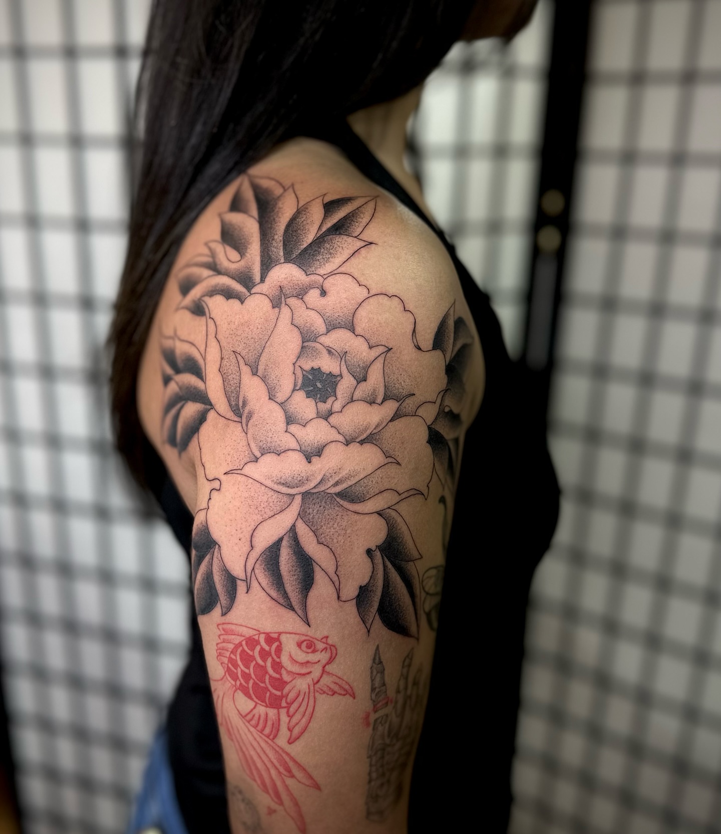 Peony and fish American traditional tattoo on the shoulder by christian martinez